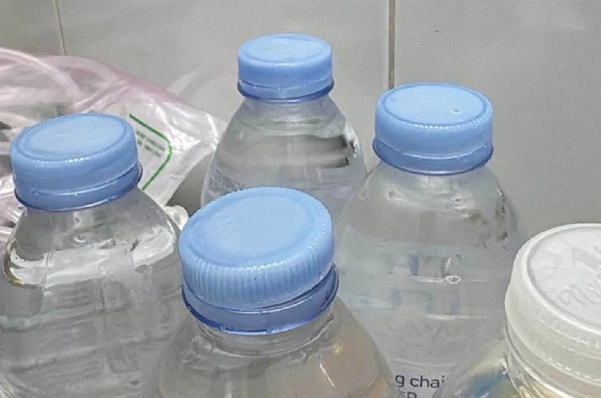 NGHỆ AN - ĐỔ NƯỚC VÀO CHAI CŨ BÁN TRƯỚC CỔNG BỆNH VIỆN, CHỦ CỬA HÀNG BỊ LẬP BIÊN BẢN image