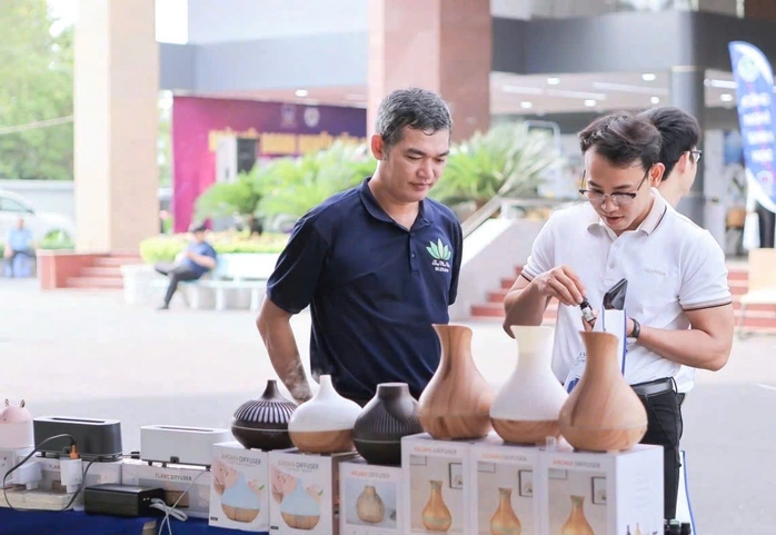 Ông Võ Bửu Lợi (trái) tại gian hàng của mình