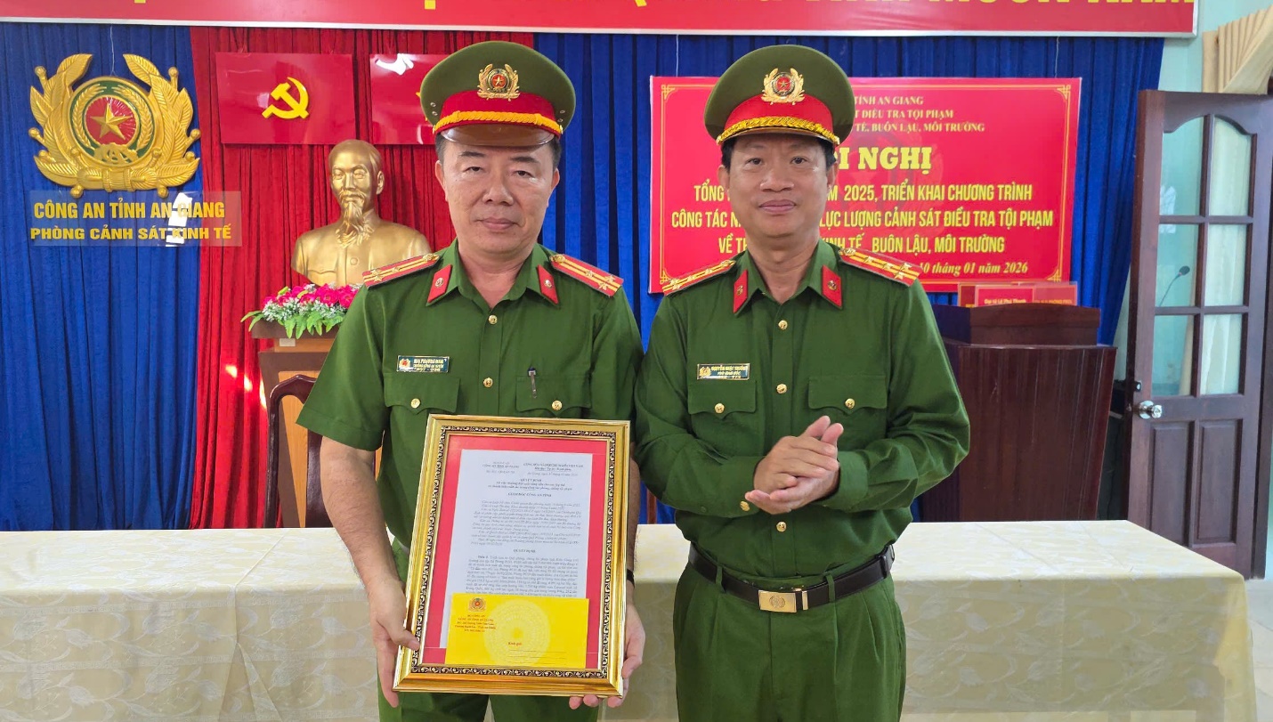 Đại tá Nguyễn Nhật Trường (phải), Phó Giám đốc Công an tỉnh An Giang, trao quyết định thưởng đột xuất 5 triệu đồng cho phòng Cảnh sát Kinh tế.